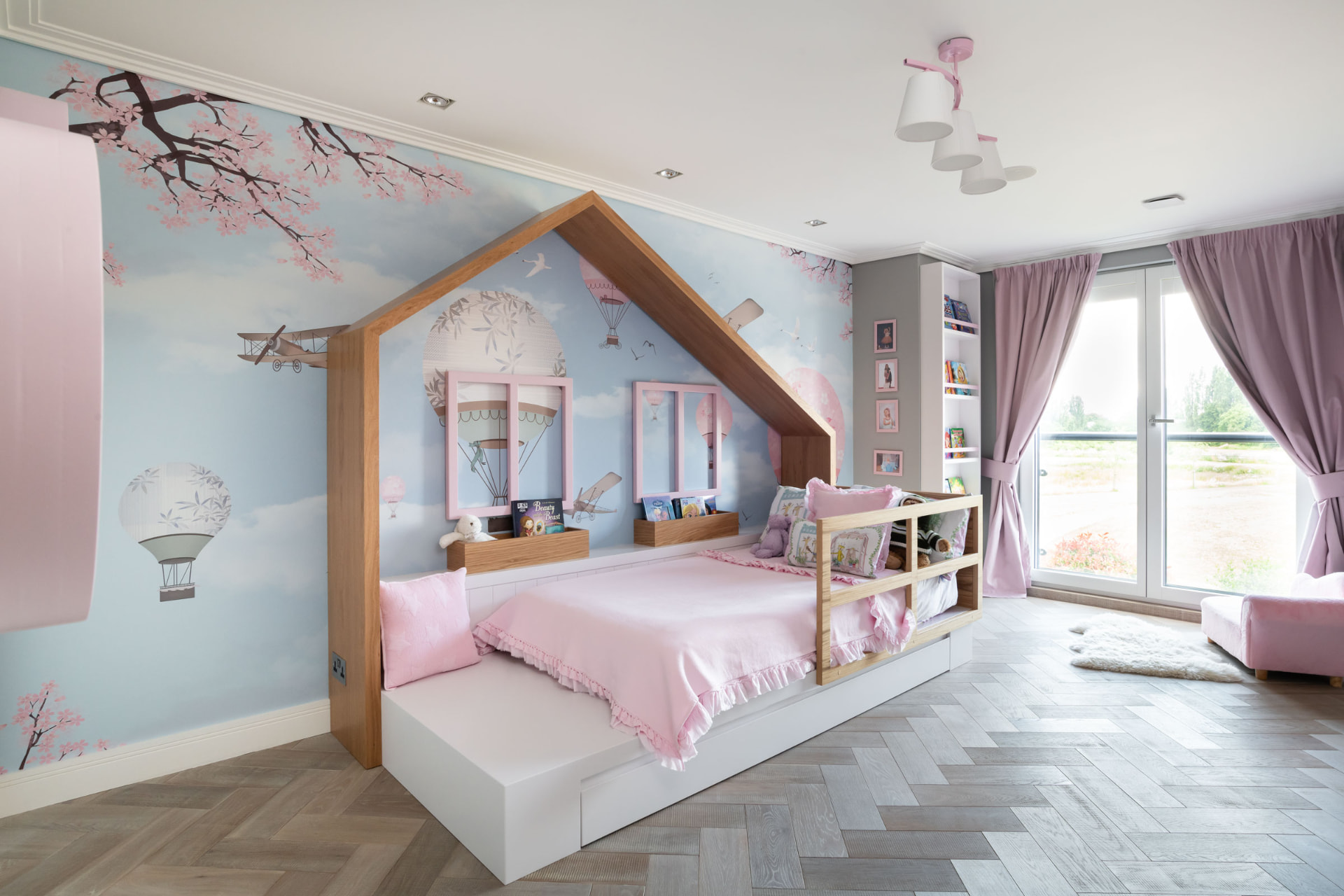 Children's bedroom with a bespoke oak house-shaped bed and blossom wallpaper